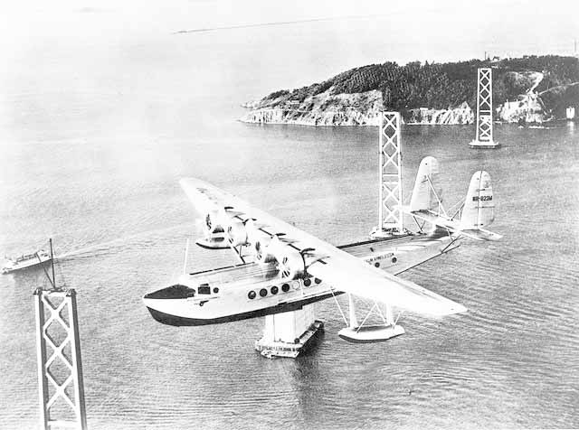 Pan American Airways Sikorsky S 42 Pan American Clipper in flight over the under construction San Francisco Oakland Bay Bridge background image